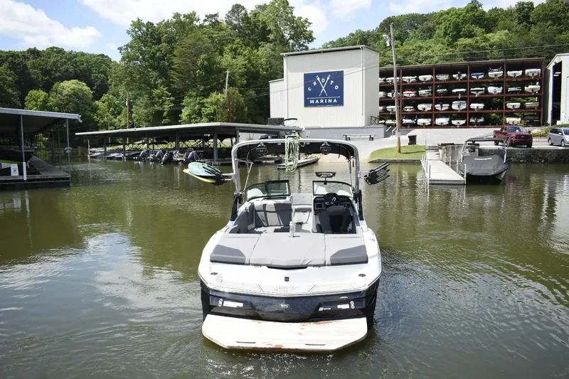 Slide: The Image of 2022 MasterCraft NXT22 boat docked at a marina with boat storage in the background. - 28