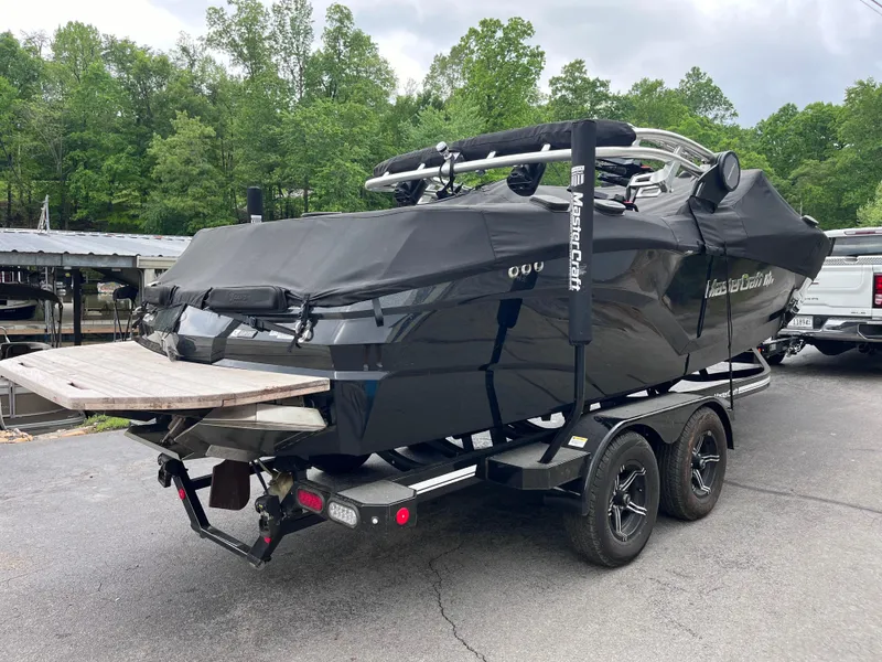 Slide: The Image of 2022 MasterCraft NXT22 boat on trailer, covered, parked outdoors. - 33