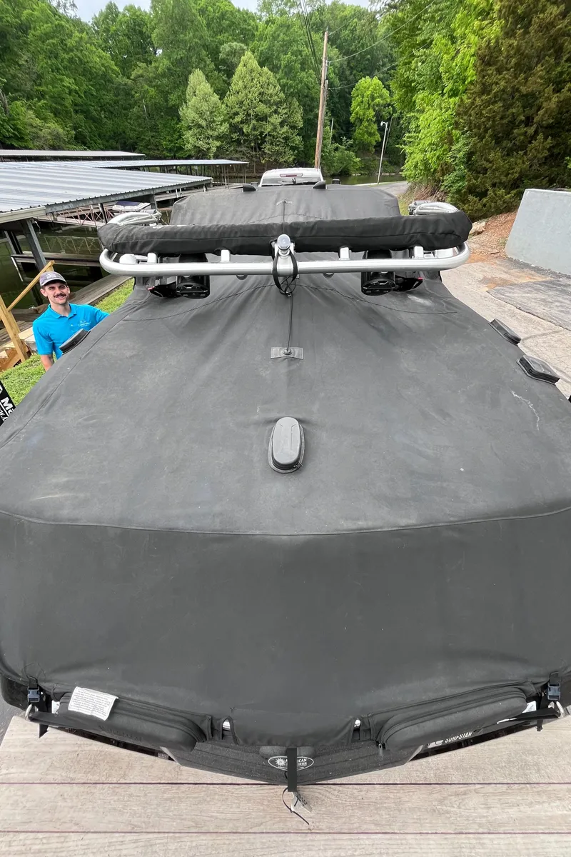 Slide: The Image of 2022 MasterCraft NXT22 boat with cover, docked near lush greenery. - 38