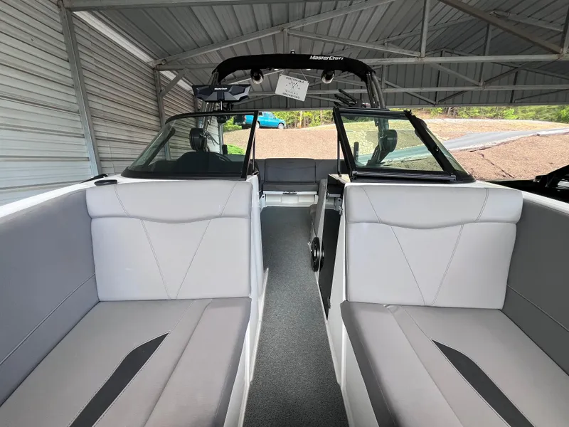 Slide: The Image of 2022 MasterCraft NXT22 boat interior with gray seating under a metal canopy. - 40