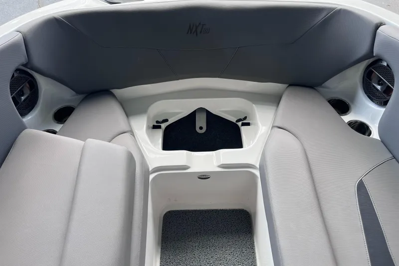 Slide: The Image of 2022 MasterCraft NXT22 boat interior with gray seating and cup holders. - 42