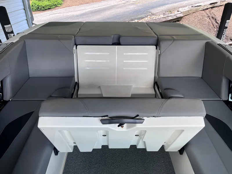 Slide: The Image of 2022 MasterCraft NXT22 boat interior with gray seating and storage compartment. - 46