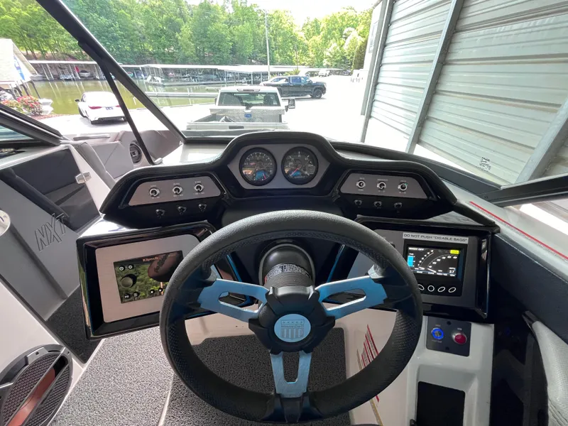 Slide: The Image of 2022 MasterCraft NXT22 boat dashboard with steering wheel and digital displays. - 48