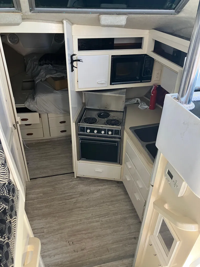 Slide: The Image of 1985 Cruisers Yachts 338 Chateau Vee interior kitchen and sleeping area. - 10