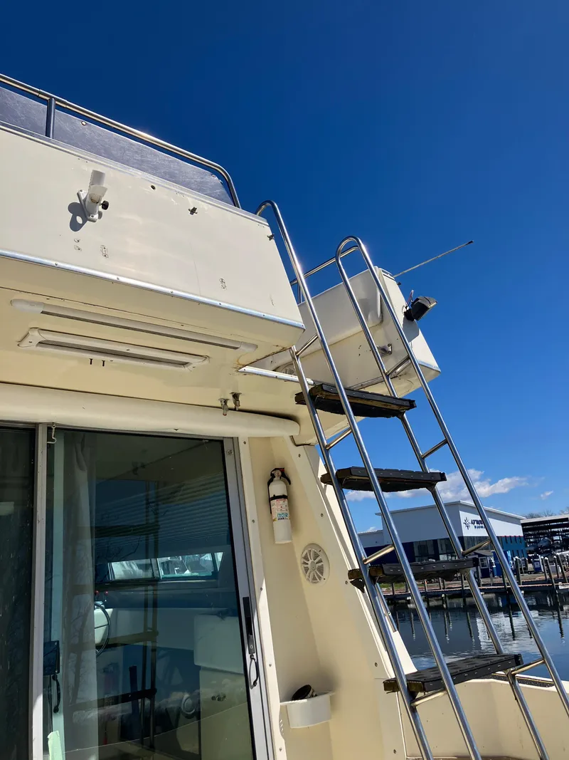 Slide: The Image of 1985 Cruisers Yachts 338 Chateau Vee, exterior view with ladder and upper deck. - 13