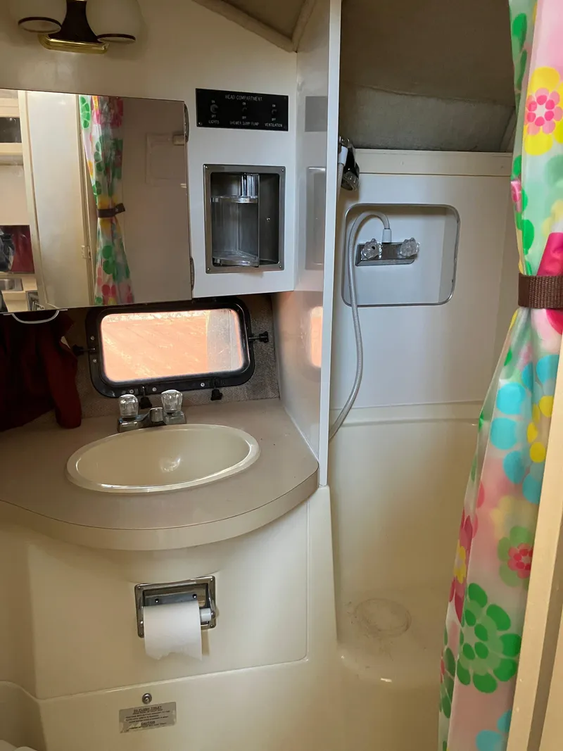 Slide: The Image of 1985 Cruisers Yachts 338 Chateau Vee bathroom with sink, mirror, and shower. - 19