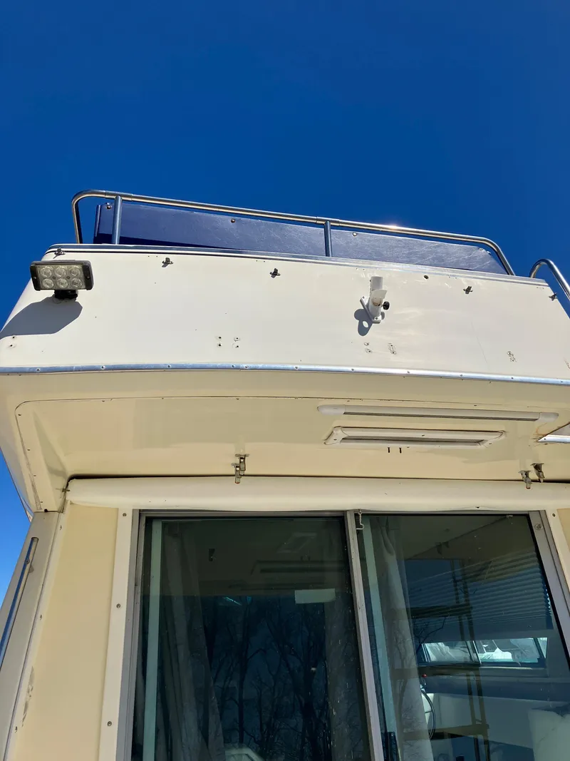 Slide: The Image of 1985 Cruisers Yachts 338 Chateau Vee, upper deck view with clear blue sky. - 8