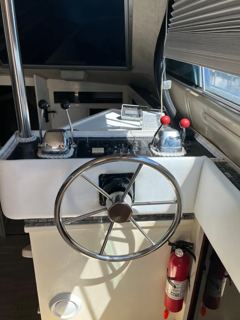 Slide: The Image of 1985 Cruisers Yachts 338 Chateau Vee helm station with steering wheel and controls. - 5