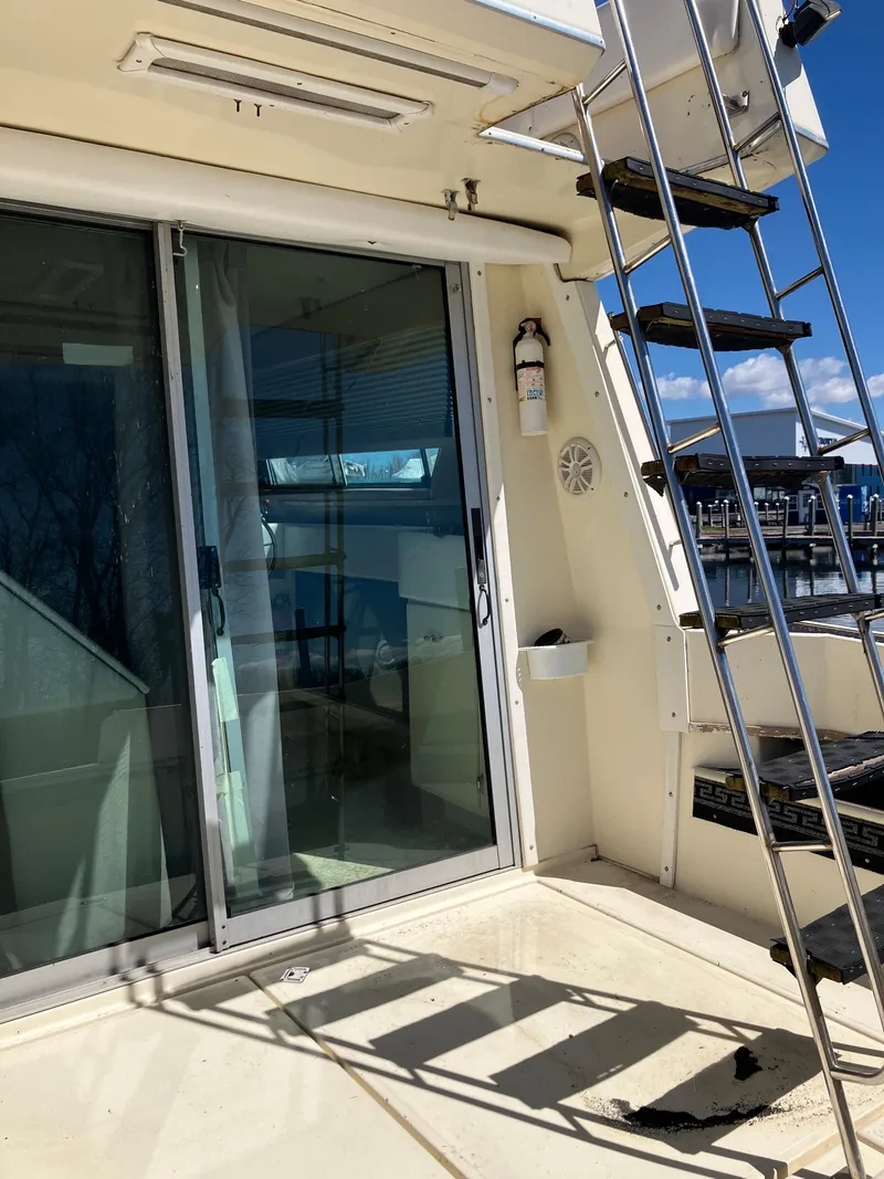 Slide: The Image of 1985 Cruisers Yachts 338 Chateau Vee, exterior view with sliding glass door and ladder. - 6