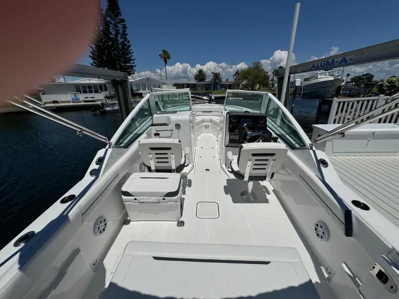 Slide: The Image of 2022 Blackfin 232 boat interior with helm and seating, docked at marina. - 14