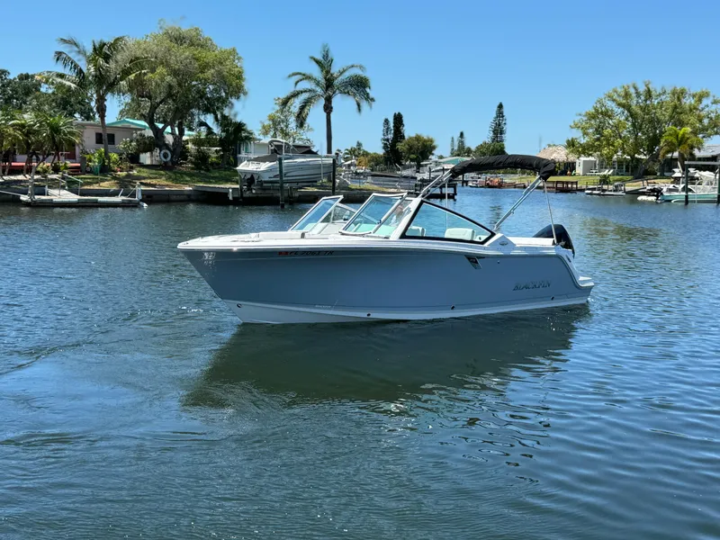 Slide: The Image of 2022 Blackfin 232 boat cruising on a sunny day in a scenic waterfront area. - 2