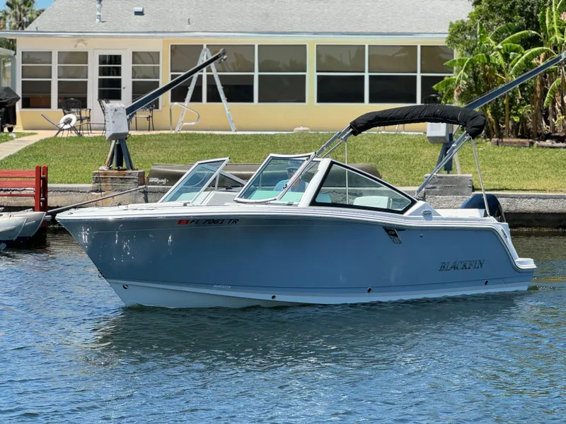Slide: The Image of 2022 Blackfin 232 boat docked near a waterfront home. - 8