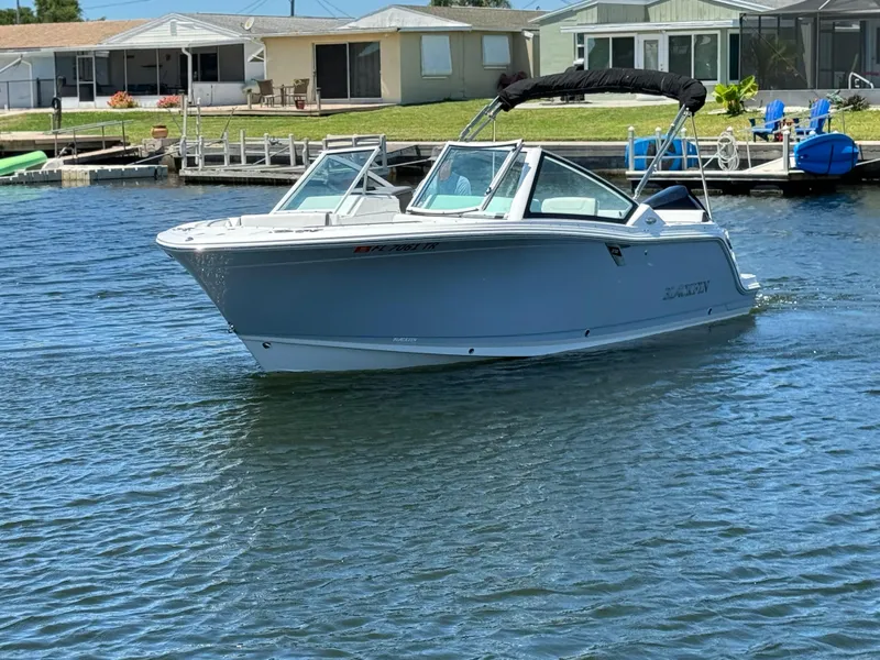 Slide: The Image of 2022 Blackfin 232 boat cruising on a sunny day near waterfront homes. - 9