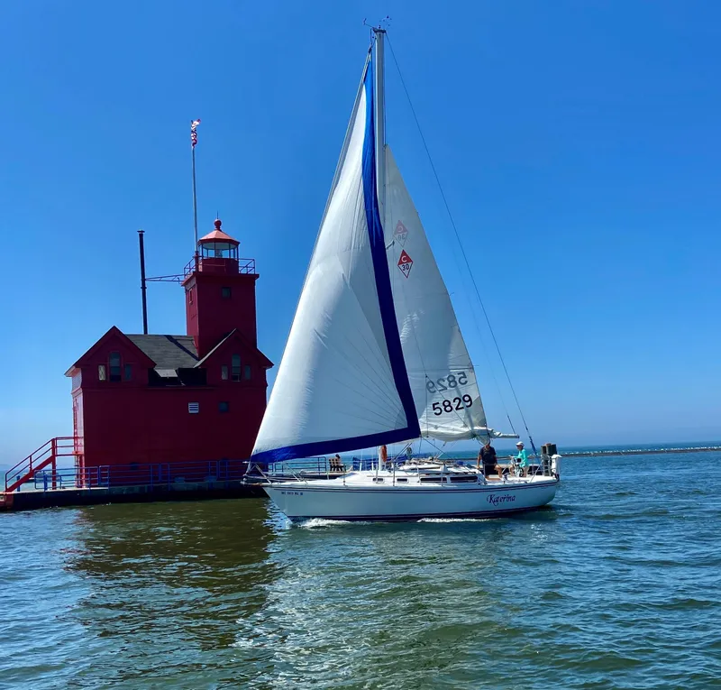 The Image of Sailboat Catalina 30' Tall Rig, 1990, near red lighthouse on a sunny day. - 0