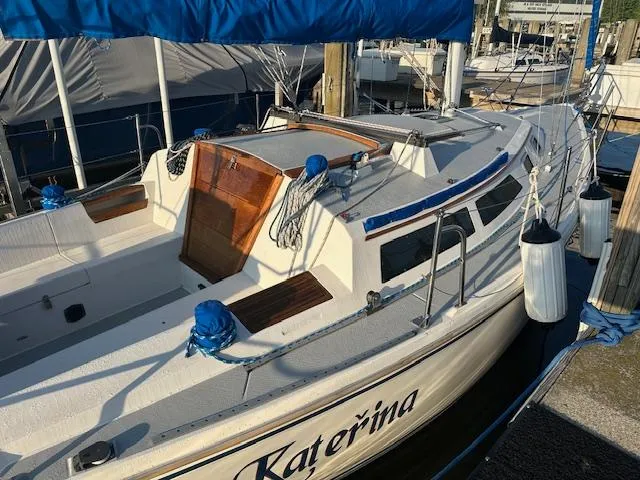 Slide: The Image of 1990 Catalina 30' Tall Rig sailboat docked, featuring a spacious cockpit and blue sail cover. - 2