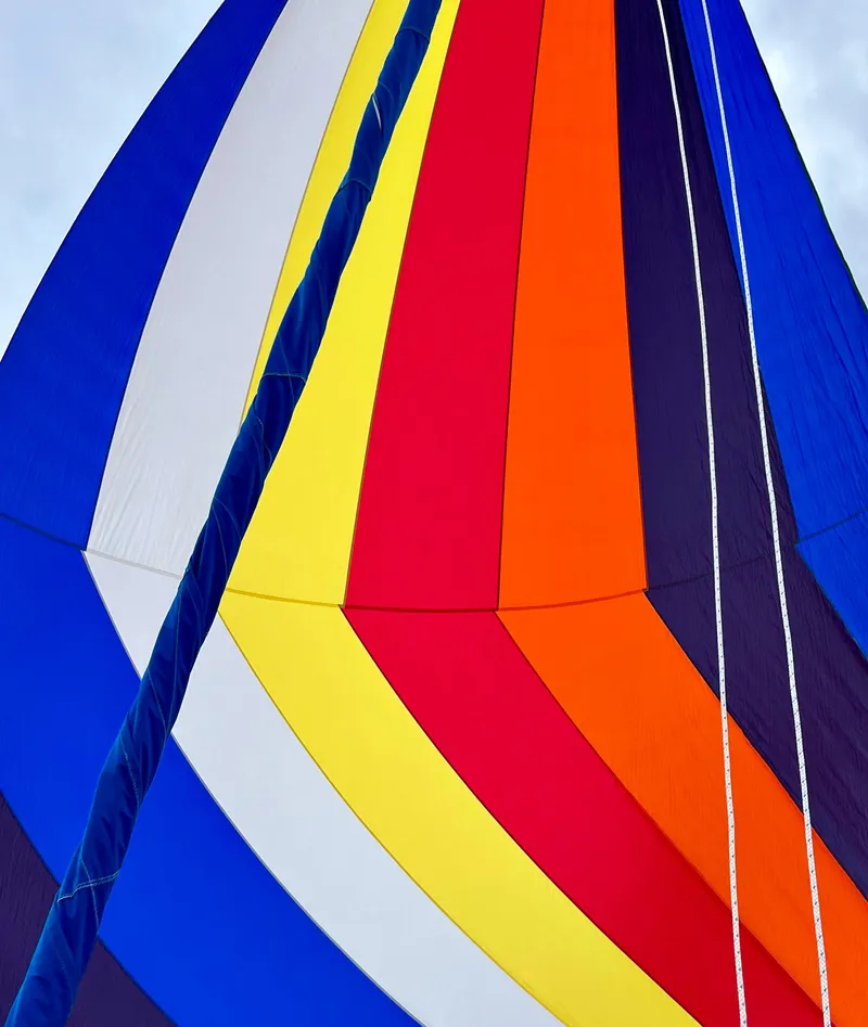 Slide: The Image of Colorful sail of a 1990 Catalina 30' Tall Rig against a cloudy sky. - 5