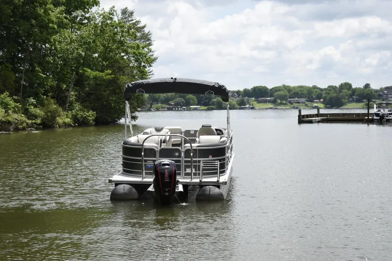 Slide: The Image of 2022 South Bay 224 RS LE pontoon boat on a serene lake. - 4