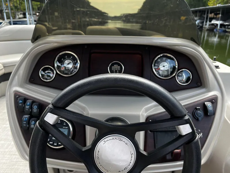 Slide: The Image of 2022 South Bay 224 RS LE boat dashboard with steering wheel and gauges. - 9