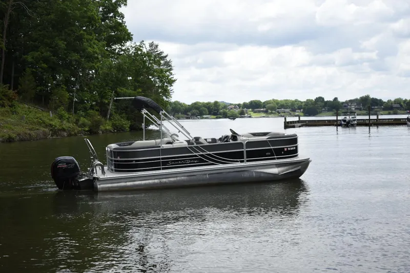 Slide: The Image of 2022 South Bay 224 RS LE pontoon boat on a lake. - 2