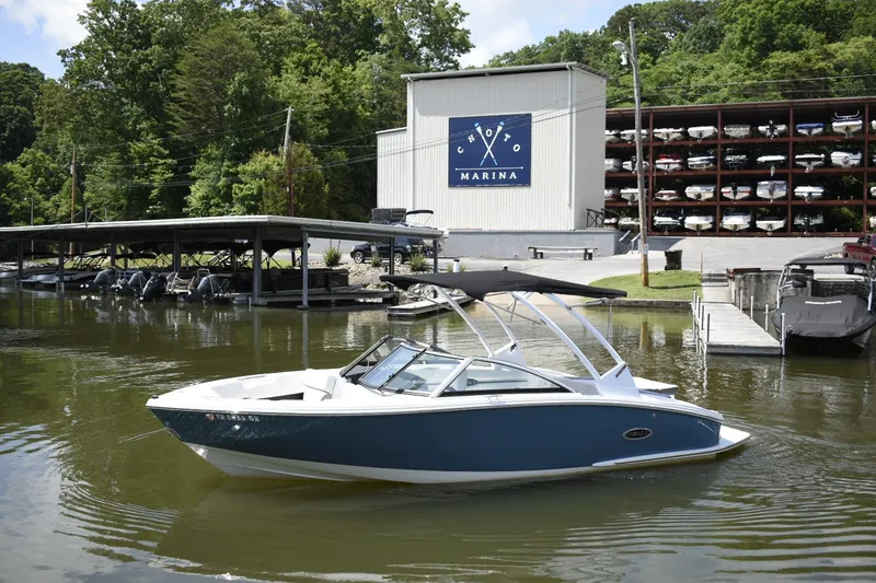 The Image of 2023 Cobalt CS22 boat docked at a marina with boat storage in the background. - 0