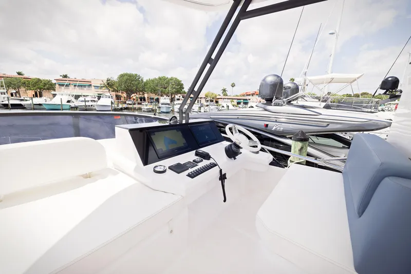 Slide: The Image of 2024 Sessa Marine Fly 48 yacht cockpit with modern controls and marina view. - 23