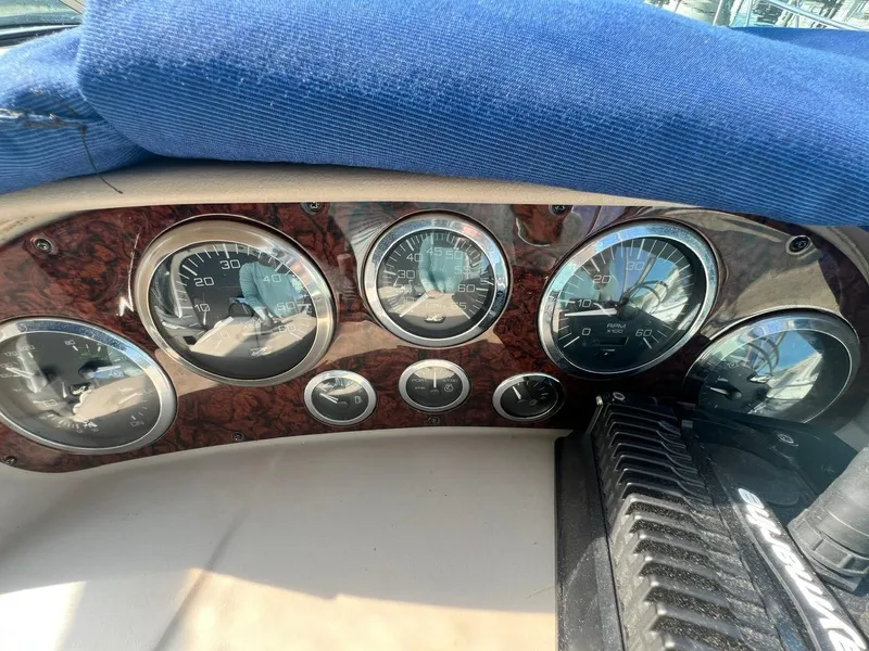 Slide: The Image of Dashboard of 2003 Sea Ray 300 Sundancer boat with gauges and blue cover. - 15