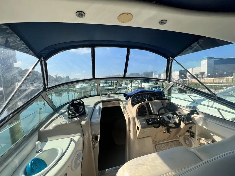 Slide: The Image of 2003 Sea Ray 300 Sundancer cockpit with blue canopy and modern controls. - 16