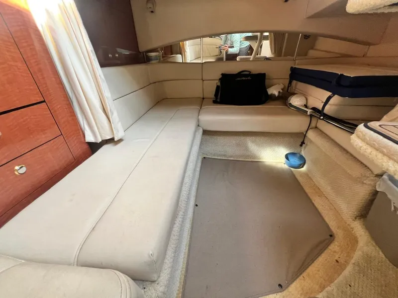 Slide: The Image of Interior of 2003 Sea Ray 300 Sundancer with beige seating and wooden cabinetry. - 18
