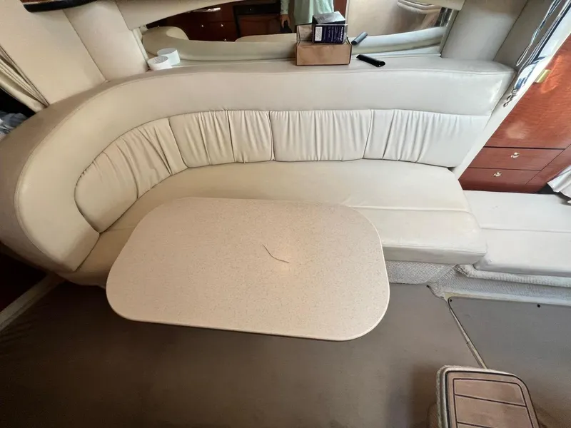 Slide: The Image of 2003 Sea Ray 300 Sundancer interior with cream seating and table. - 19