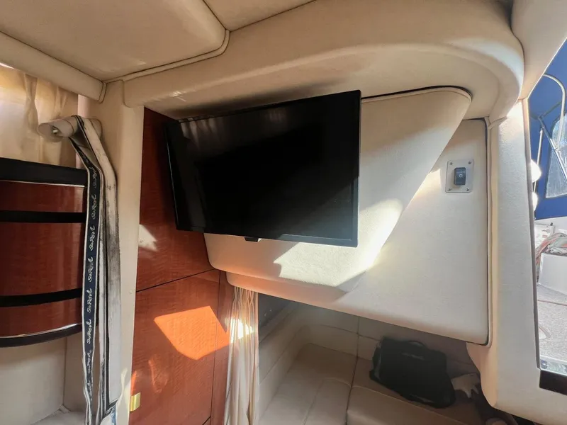 Slide: The Image of Interior of 2003 Sea Ray 300 Sundancer with mounted TV and wooden cabinetry. - 23