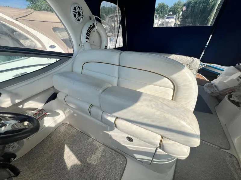 Slide: The Image of Interior of 2003 Sea Ray 300 Sundancer with white seating and steering wheel. - 8
