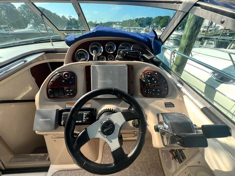 Slide: The Image of Cockpit of 2003 Sea Ray 300 Sundancer with steering wheel and control panel. - 9