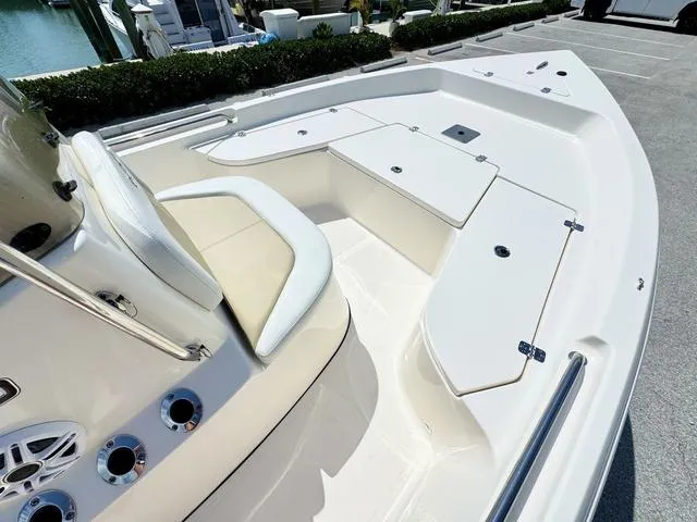 Slide: The Image of 2024 Bulls Bay 2000 boat with spacious seating and storage compartments, docked near water. - 10