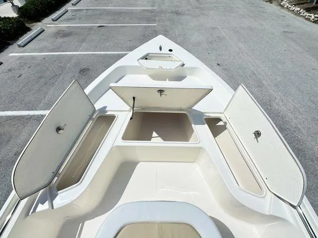 Slide: The Image of 2024 Bulls Bay 2000 boat with open storage compartments in a parking lot. - 11