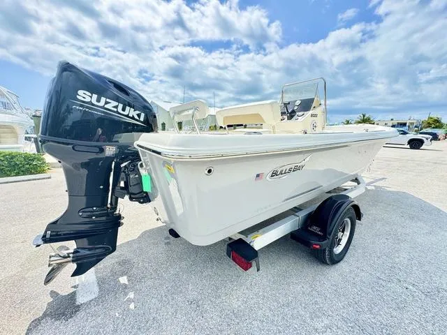 Slide: The Image of 2024 Bulls Bay 2000 boat with Suzuki outboard motor on a trailer, under a cloudy sky. - 14