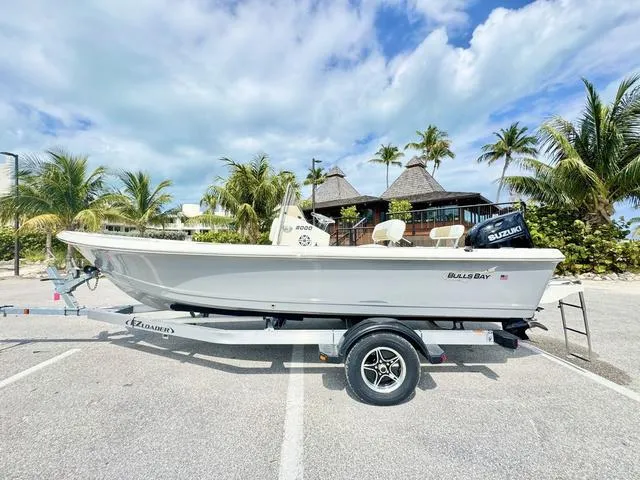 Slide: The Image of 2024 Bulls Bay 2000 boat with outboard motor in a marina. - 2