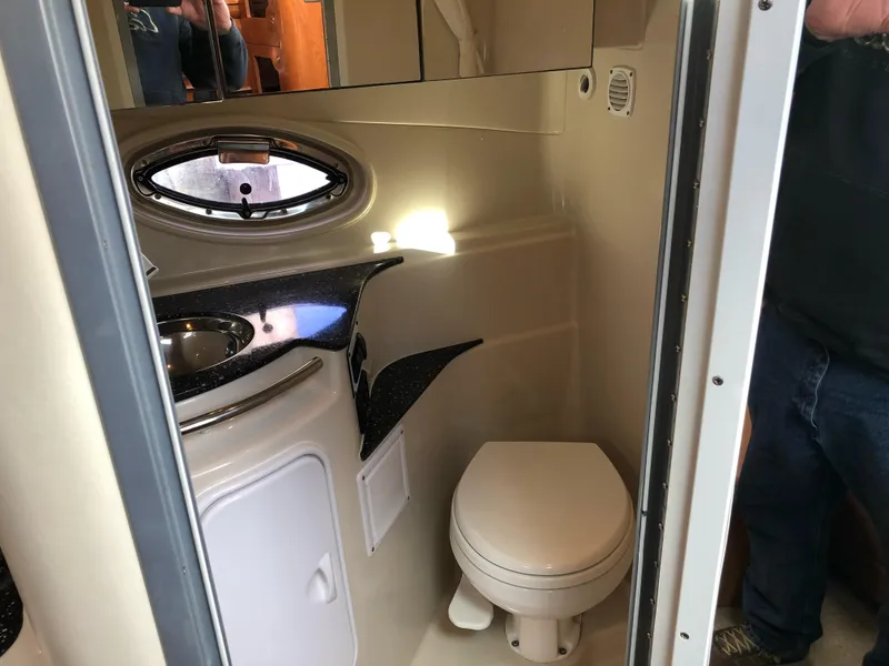 Slide: The Image of 2007 Four Winns 318 Vista boat bathroom with sink, toilet, and porthole window. - 14
