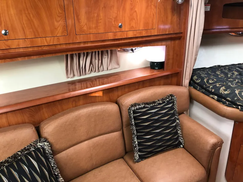 Slide: The Image of 2007 Four Winns 318 Vista interior with brown leather seating and wooden cabinetry. - 17