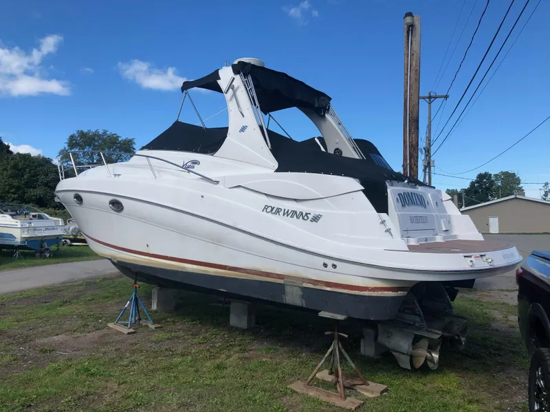 Slide: The Image of 2007 Four Winns 318 Vista boat on stands, black canopy, parked outdoors. - 7