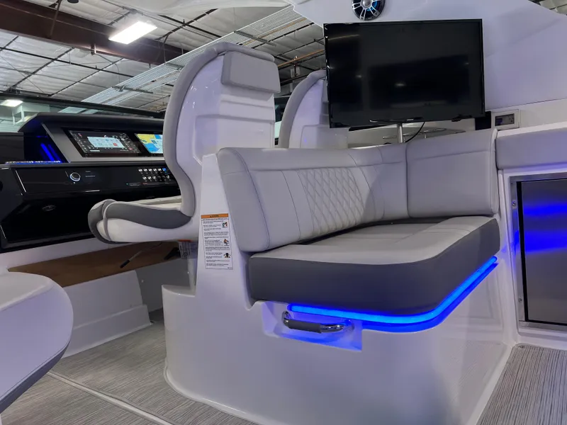 Slide: The Image of 2024 Sea Ray SLX 400 interior with modern seating, blue LED lighting, and a mounted screen. - 15