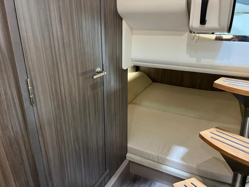 Slide: The Image of 2024 Sea Ray SLX 400 cabin interior with bed and wooden accents. - 25