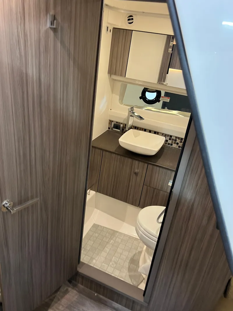 Slide: The Image of 2024 Sea Ray SLX 400 yacht bathroom with modern wood finish and sleek fixtures. - 26