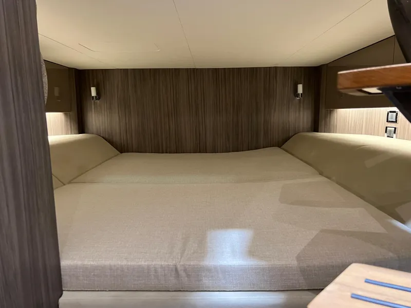 Slide: The Image of 2024 Sea Ray SLX 400 cabin interior with cozy bed and modern wood paneling. - 27