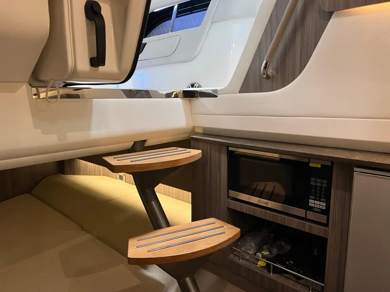Slide: The Image of 2024 Sea Ray SLX 400 interior with wooden steps and built-in microwave. - 28