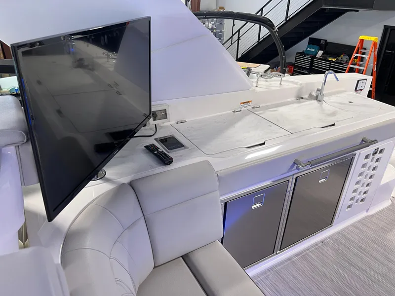 Slide: The Image of 2024 Sea Ray SLX 400 yacht interior with TV, seating, and kitchenette area. - 48