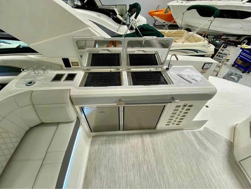 Slide: The Image of 2024 Sea Ray SLX 400 boat interior with kitchenette and seating area. - 65