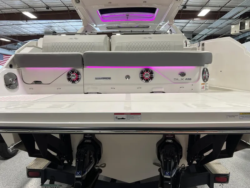 Slide: The Image of 2024 Sea Ray SLX 400 boat with illuminated speakers and sleek design in a showroom. - 7