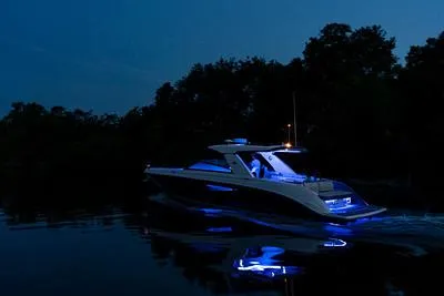 Slide: The Image of 2024 Sea Ray SLX 400 boat illuminated at night on calm water. - 75