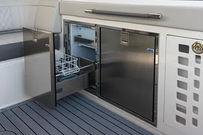 Slide: The Image of 2024 Sea Ray SLX 400 yacht interior with open stainless steel refrigerator and storage. - 89