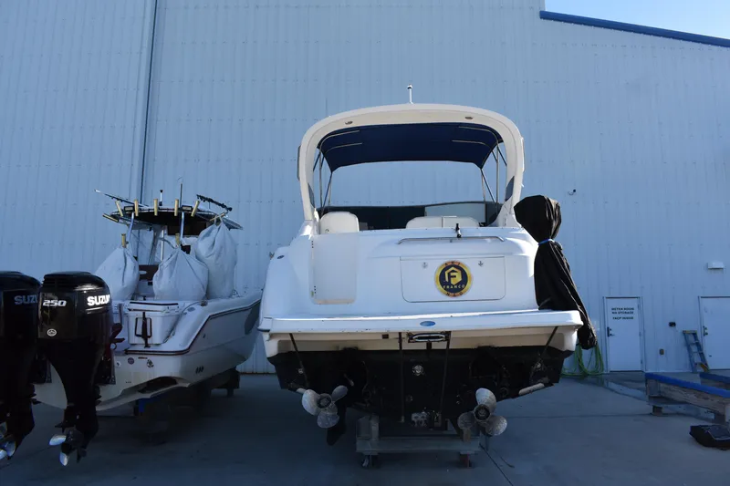 Slide: The Image of 2003 Bayliner 305 boat in storage, rear view, next to another boat. - 16